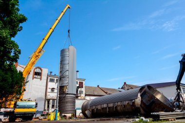 Mobil vinç büyük eski metal tank aşağı yatıyordu