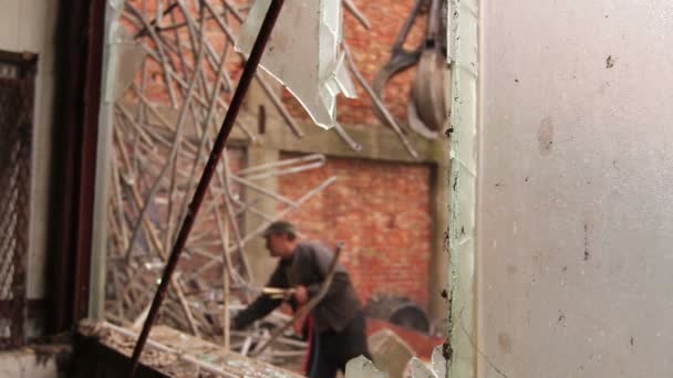 Blick Durch Zerbrochenes Fenster Auf Arbeiter Der Kleine Rohre Schneidet — Stockvideo