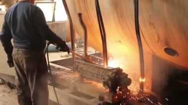 İşçi oksijen ve asetilen, propan gaz karışımı kullanarak elle eski, hurda, metal konstrüksiyon kesiyor. Fotoğraf - Jpeg video codec