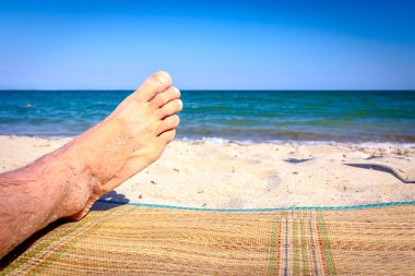 Sahilde adamın bacakları, kumlu plajda rahatlatıcı