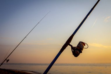 Gün doğumunda sahilde birkaç olta 