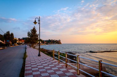 Sahil şeridinin yanındaki halk plajının üzerindeki gezinti şeridi, Sabah ışığı