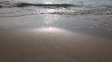 Deniz kumlu plajda köpüklü dalgalar kırıyor, sahil. Kıyı şeridinde küçük dalgalar üzerinde düşük açı görünümü, köpüklü dalgalar ile deniz. Fotoğraf - Jpeg video codec