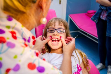 Gözlüklü tatlı küçük kız portresi, diş hekimi kapalı çocuk