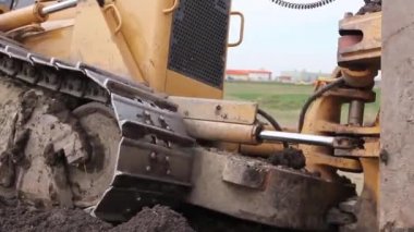 Şantiyede itme zemini sırasında buldozerin alt arabası yakından görünümü. H.264 video codec