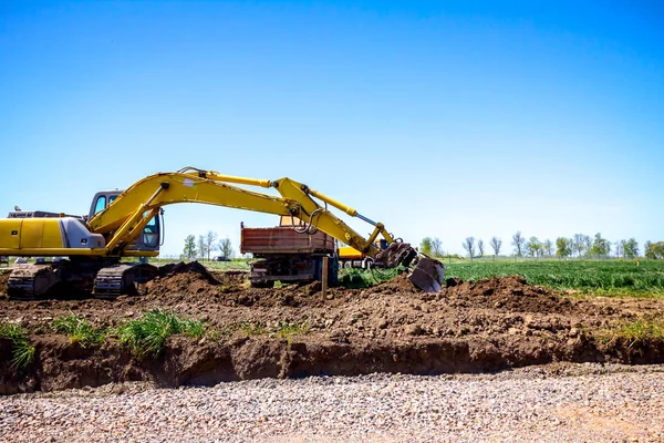 Ekskavatör bina site üzerinde zemin ile bir kamyon yükleniyor