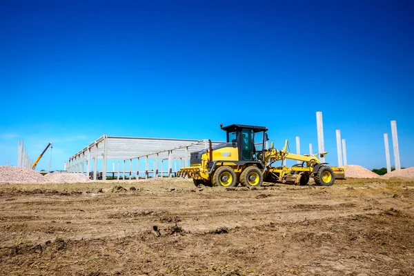 Grader está nivelando el terreno en el sitio de construcción — Foto de Stock