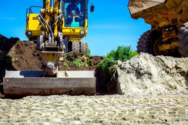 Ekskavatör bina site üzerinde zemin ile bir kamyon yükleniyor