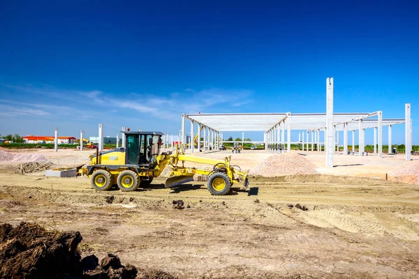 Grader está nivelando el terreno en el sitio de construcción — Foto de Stock