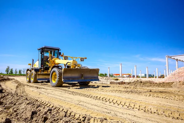 Grader está nivelando el terreno en el sitio de construcción — Foto de Stock