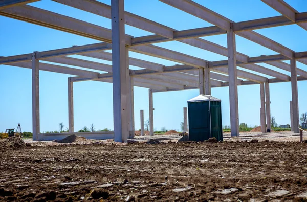 Betonbau mit mobiler Kunststofftoilette im Bau — Stockfoto