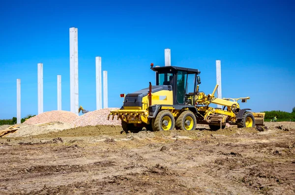 Grader está nivelando el terreno en el sitio de construcción — Foto de Stock