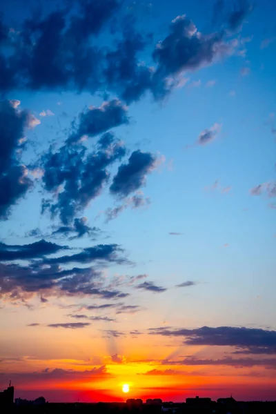 Céu azul com nuvens brancas ao pôr do sol, cidade à distância — Fotografia de Stock