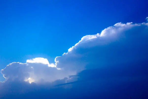 Raios de luz solar das nuvens em um céu azul — Fotografia de Stock