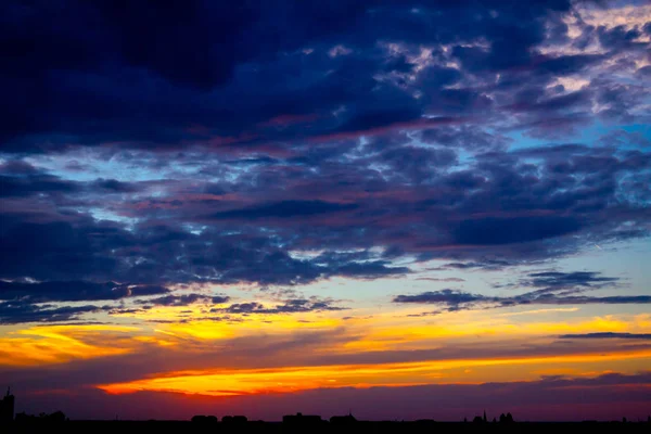 Blå himmel med vita moln vid solnedgången, stad i fjärran — Stockfoto