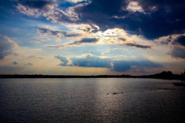 Göl üzerinde bulutlu gün batımı