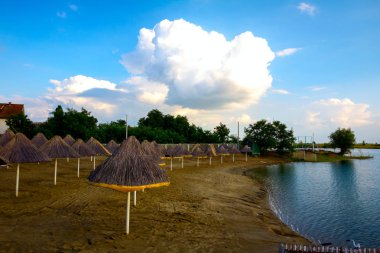 Sazdan güneşlikleri ile göl kenarında boş kumlu plaj