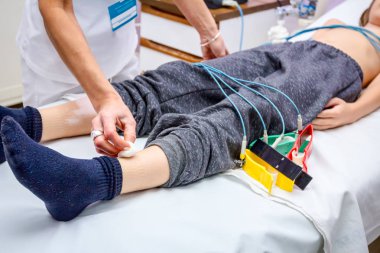 Hemşire ekg veya Ekg testi için bir çocuk, genç hasta hazırlanıyor