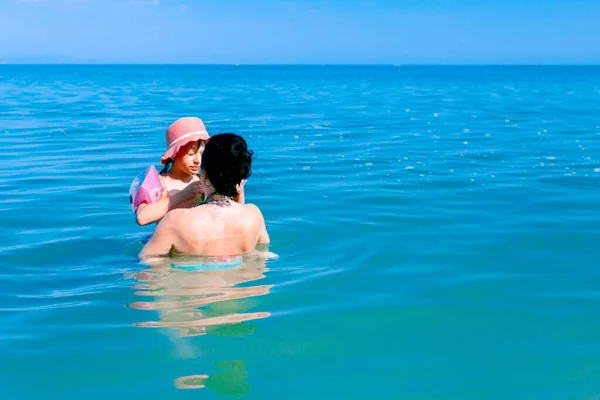 Ragazza indossa bracciali gonfiabili, imparare a nuotare nel mare — Foto Stock