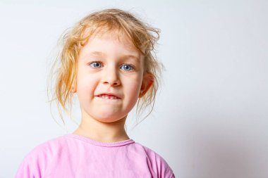Komik ve neşeli küçük kızın portresi Komik bir yüz ifadesi yapana kadar.