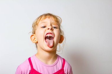 Tatlı küçük kızın portresi Dilini dışarı çıkarıyor, sürünen dil.