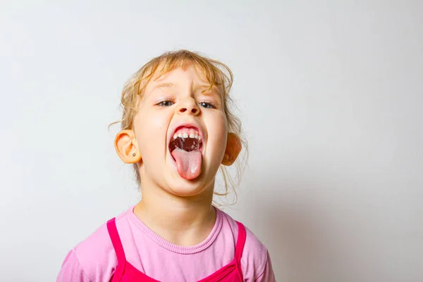 Tatlı küçük kızın portresi Dilini dışarı çıkarıyor, sürünen dil.