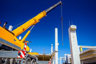 Vinçler-Mobil vinç zinciri üzerinde asılı büyük bir beton kiriş ile çalışma.