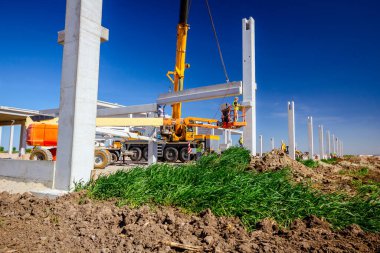 İşçiler için derleme büyük inşaat beton kiriş yönetmek için Mobil vinç yardımcı oluyor.
