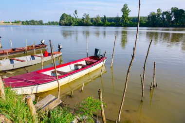 Balıkçı tekneleri nehrin doğaçlama rıhtımına demirlediler..
