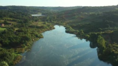 Drone yavaşça yüzen buhar üzerinde uçuyor, şafak vakti gölün üzerinde buhar, güneş ışınlarıyla gün doğumu..