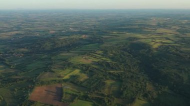 Dolly yeşil tepe üzerinde çekim yaptı. Orman ağaçları arasında ekilmiş araziler..