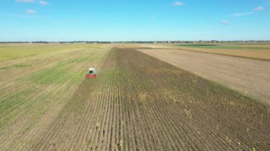 Tarımsal hasatçıların üstünde tarım tarlalarında olgun ayçiçekleri kesip biçmek var..