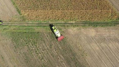 Zirai hasat aracının havadan görünüşü tarım arazilerindeki olgun ayçiçeklerini kesip biçiyor..