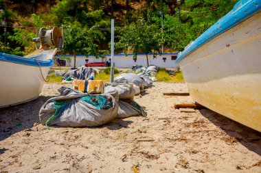 Balık ağı yığını, balıkçı tekneleri arasındaki kumlu sahilde..
