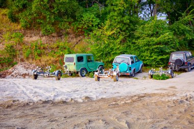 Plajda birkaç araba ve nakliye gemileri için römorklar var..