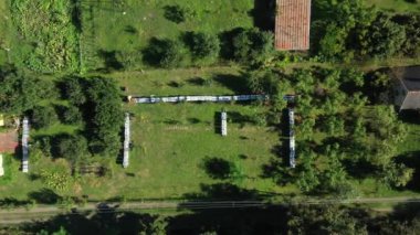 Yavaşça aşağı in, yukarıdan aşağıya doğru çekilen oyuncak bebek, arıcı çizgi halinde sıralanmış ahşap renkli arı kovanlarındaki durumu kontrol ediyor.. 