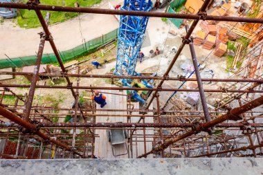 İskele, yapıya karşı kurulur. Patron inşaat alanının üstündeki ahşap platformdan denetliyor..