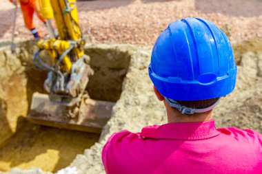 İnşaat işçisi, ustabaşı, inşaat alanında güvenlik mavi kasklı, proje devam ediyor..