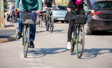 Bisiklet süren, şehirde bisiklete binen, kalabalık içinde araba kullanan bir grup genç, trafikteki ve kentsel çevredeki bisikletçiler için tehlikelere dikkat çekmeye çalışıyor.. 