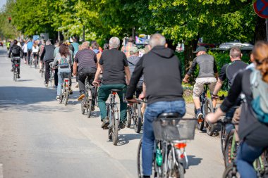 Bisiklet süren, şehirde bisiklete binen, kalabalık içinde araba kullanan bir grup genç, trafikteki ve kentsel çevredeki bisikletçiler için tehlikelere dikkat çekmeye çalışıyor.. 