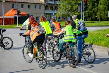 Bisiklet süren, şehirde bisiklete binen, kalabalık içinde araba kullanan bir grup genç, trafikteki ve kentsel çevredeki bisikletçiler için tehlikelere dikkat çekmeye çalışıyor.. 