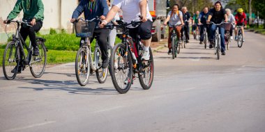 Bisiklet süren, şehirde bisiklete binen, kalabalık içinde araba kullanan bir grup genç, trafikteki ve kentsel çevredeki bisikletçiler için tehlikelere dikkat çekmeye çalışıyor.. 