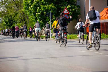 Bisiklet süren, şehirde bisiklete binen, kalabalık içinde araba kullanan bir grup genç, trafikteki ve kentsel çevredeki bisikletçiler için tehlikelere dikkat çekmeye çalışıyor.. 