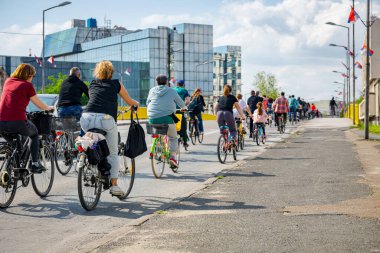 Bisiklet süren, şehirde bisiklete binen, kalabalık içinde araba kullanan bir grup genç, trafikteki ve kentsel çevredeki bisikletçiler için tehlikelere dikkat çekmeye çalışıyor.. 