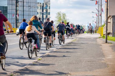 Bisiklet süren, şehirde bisiklete binen, kalabalık içinde araba kullanan bir grup genç, trafikteki ve kentsel çevredeki bisikletçiler için tehlikelere dikkat çekmeye çalışıyor.. 