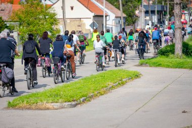 Bisiklet süren, şehirde bisiklete binen, kalabalık içinde araba kullanan bir grup genç, trafikteki ve kentsel çevredeki bisikletçiler için tehlikelere dikkat çekmeye çalışıyor.. 