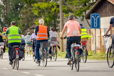 Bisiklet süren, şehirde bisiklete binen, kalabalık içinde araba kullanan bir grup genç, trafikteki ve kentsel çevredeki bisikletçiler için tehlikelere dikkat çekmeye çalışıyor.. 