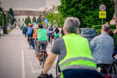 Bisiklet süren, şehirde bisiklete binen, kalabalık içinde araba kullanan bir grup genç, trafikteki ve kentsel çevredeki bisikletçiler için tehlikelere dikkat çekmeye çalışıyor.. 