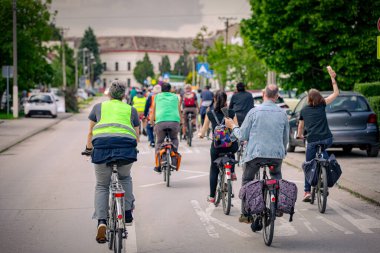 Bisiklet süren, şehirde bisiklete binen, kalabalık içinde araba kullanan bir grup genç, trafikteki ve kentsel çevredeki bisikletçiler için tehlikelere dikkat çekmeye çalışıyor.. 