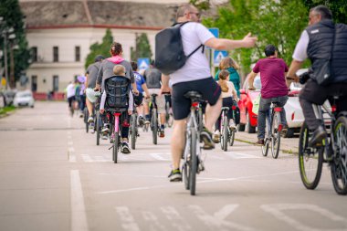 Bisiklet süren, şehirde bisiklete binen, kalabalık içinde araba kullanan bir grup genç, trafikteki ve kentsel çevredeki bisikletçiler için tehlikelere dikkat çekmeye çalışıyor.. 